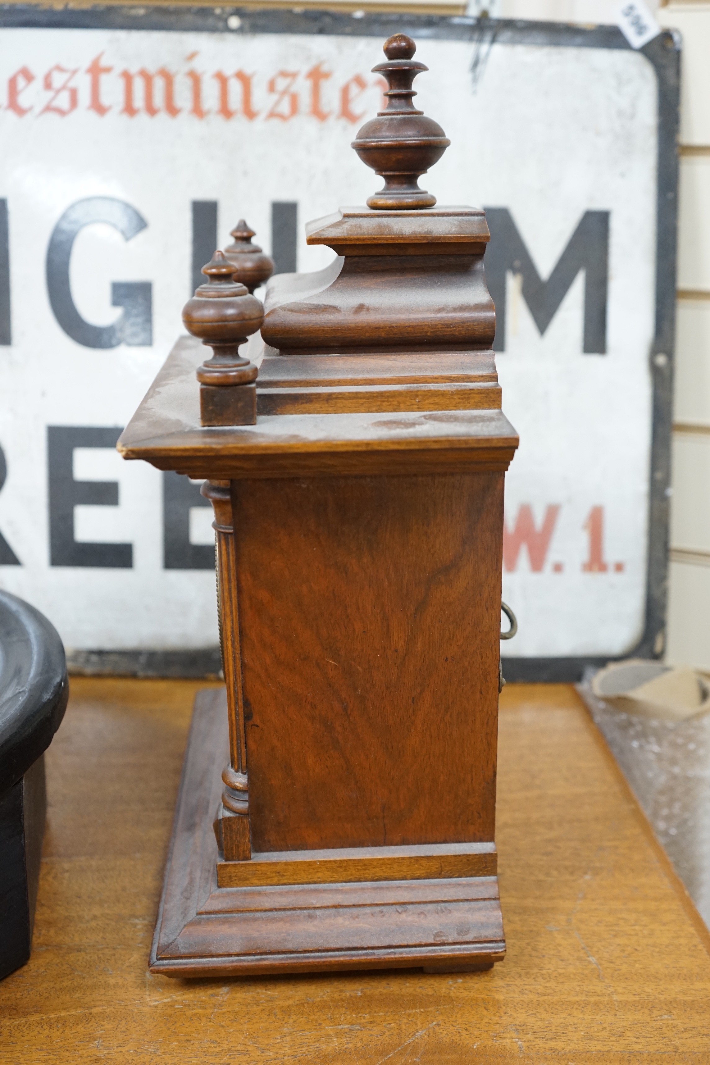 A 19th century German walnut mantel clock with key and pendulum, 40cm tall
